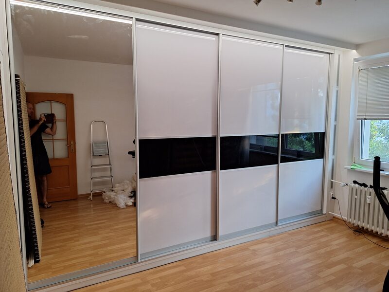 Biela posuvná skriňa s čiernym profilom a zrkadlom